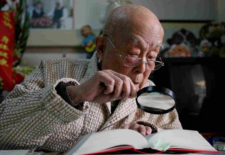 2006年1月26日，95岁的北京大学教授季羡林在就医的解放军总医院借助高倍放大镜读书。  